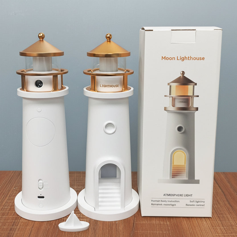 Two white lighthouse-shaped lamps with gold accents, packaging, and accessories on a wooden surface.